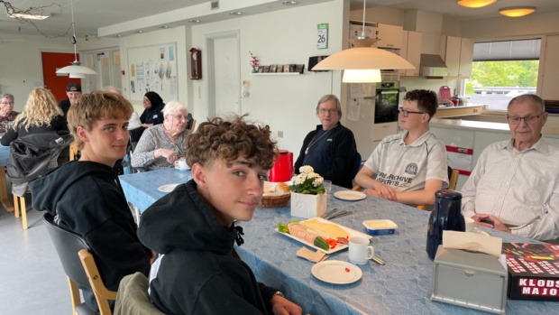 Foto: I forgrunden Noah (tv) og Bertel omkring et af kaffebordene, hvor unge og gamle hygger og snakker som opvarmning til andre aktiviteter.